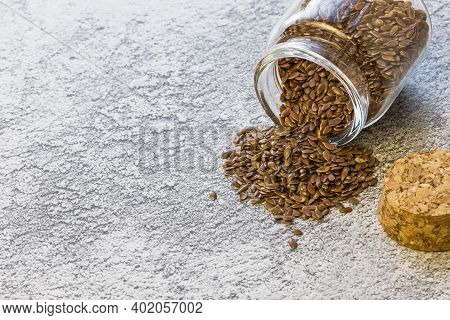 Herbal Alternative Medicine And Cosmetology, Flax Seed In A Glass Jar Poured On The Table, A Source 