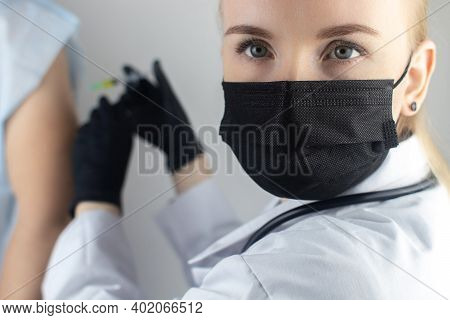 Infectious Disease Doctor Gives The Patient A Medical Vaccination In The Shoulder. Immunization Agai