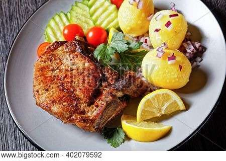 Roasted Pork Karbonade, Pork Cutlets With Boiled Potato And Sliced Cucumber And Lemon On A Plate On 