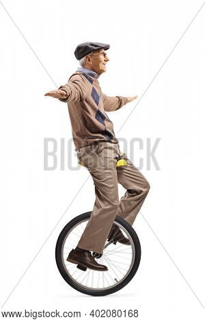 Full length profile shot of an elderly man riding a mono-cycle and spreading arms isolated on white background