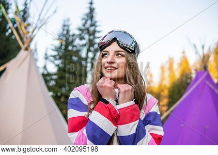 Portrait Of Pretty Caucasian Young Woman Near The Indian Tipi Or Wigwam In Ski Outfit And Winter Spo