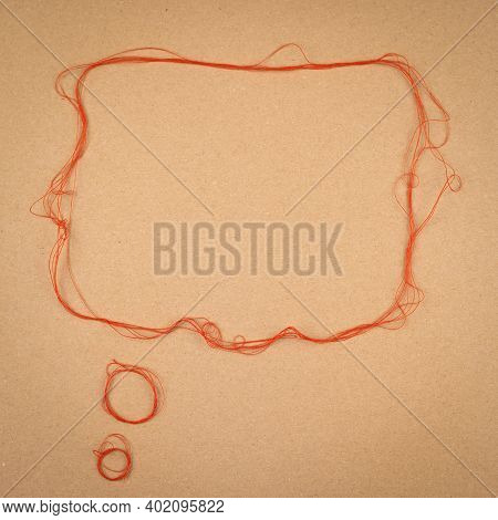 Speech Or Think Bubble Made Of Thread, Red Rope. Thematical Copy Space On Cardboard Textured Backgro