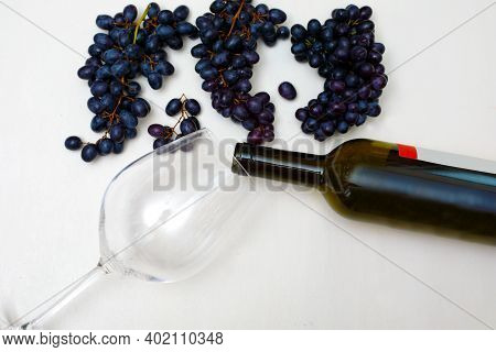 Bunches Of Grapes With A Bottle Of Wine And A Glass On A White Background. Harvesting Grapes And Pre