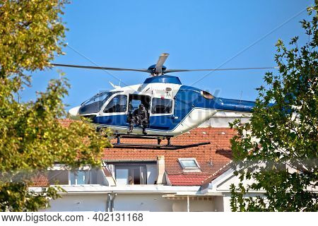 Police Sniper In Helicopter Urban Area Low Flight View, Masked And Unrecognizable Special Aerial For