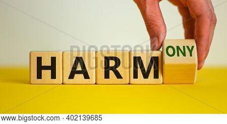 From Harm To Harmony. Male Hand Turns The Cube And Changes Word 'harm' To 'harmony'. Beautiful Yello
