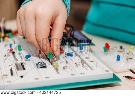 Close-up Of Hand Of Child Engaged In Creation Of Models From Programmable Radio Parts From Arduino