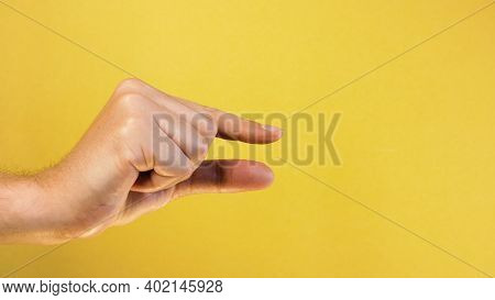 Woman Caucasian Hand Gesture Of Showing Small Size With Two Fingers, Isolated Over Yellow Background