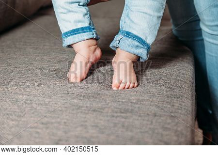 Baby's First Steps. The Baby's Feet Take The First Steps. Photo Of Children's Legs Barefoot.