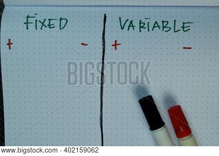 Fixed And Variable Write On A Book Isolated On Wooden Table.