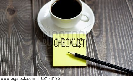 Business Cheklist Yellow Stickers With Text On The Wooden Background With Coffee