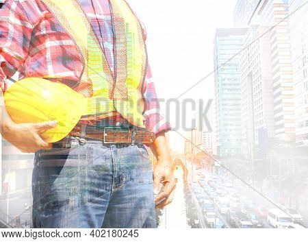 Dubble Exprosere Of Engineer In Safety Suit Holding Yellow Helmet With Blur City Scape Background , 
