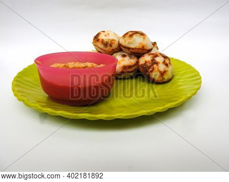 Paddu Or Kuzhi Paniyaram And Coconut Chutney In A Green Plate Isolated On White Background. Indian D