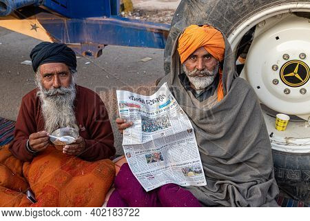 New Delhi, India - December 2020:
Portrait Of A Group Of Farmer Reading News Paper During The Protes