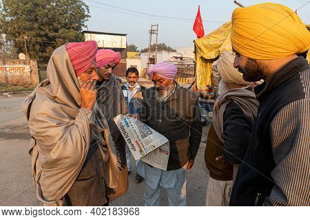 New Delhi, India - December 2020:
Portrait Of A Group Of Farmer Reading News Paper During The Protes