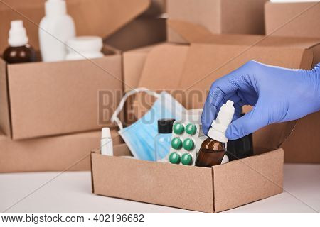 Pharmacists Hand Putting A Bottle Of Nasal Drops Into A Box With Medications