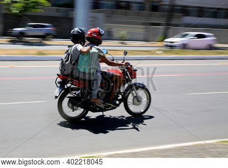 Motorcyclist Is Seen Walking Down The Street