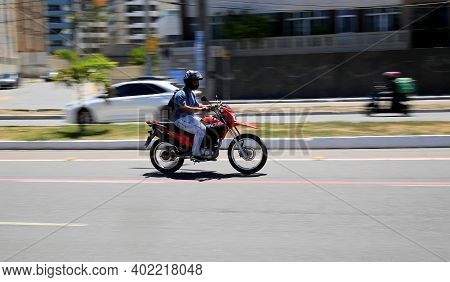 Motorcyclist Is Seen Walking Down The Street