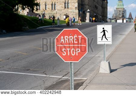 Stop Sign Seen In Front Of Government Building In Ottawa, Ontario, Canada. Sign Is In French And Eng