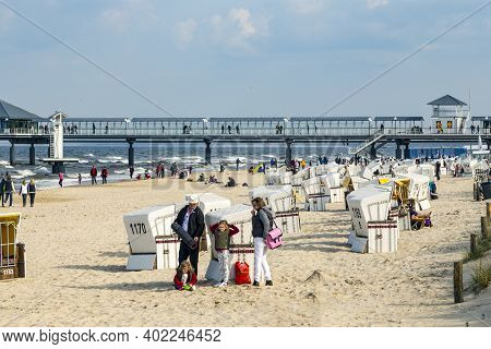 Heringsdorf, Germany - April 20, 2014: People Enjoy Pier And Beach Of Heringsdorf, Germany. The Balt