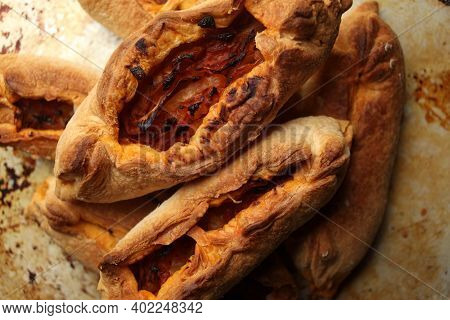 Twisted Pastry Stuffed With Cabbage On The Table. Russian Open Pirozhki, Baked Patties Stuffed With 