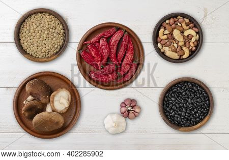 Beans, Nuts, Chili Peppers, Mushrooms And Garlic Over Wooden Table.