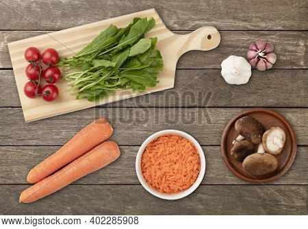 Vegetables And Salad Ingredients Over Wooden Table.