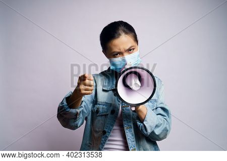 Asian Woman Wearing Protective Face Mask Shouting With Megaphone Isolated Over White Background.