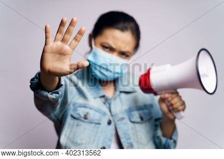 Asian Woman Wearing Protective Face Mask Shouting With Megaphone Isolated Over White Background.