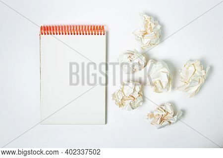 A Blank Sheet Of Notebook With Crumpled Paper Around. Crumpled Paper On A White Background. Creative