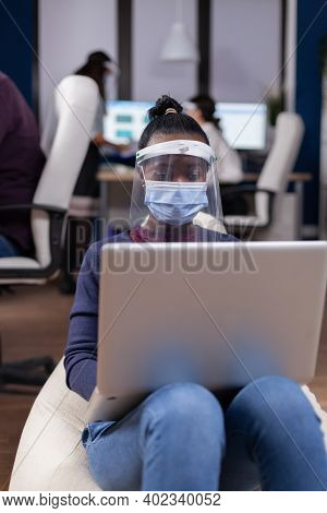 African Manager In Comany Using Laptop Wearing Face Mask Against Covid. Multiethnic Business Team Wo