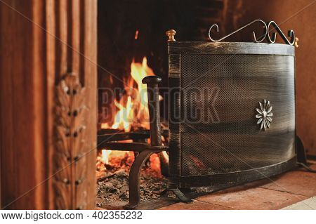 Fire In A French Old Fireplace With A Fire Shield