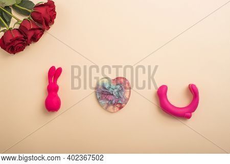 Rose Heart And Clitoral Vibrator On A Beige Background. Flat Lay