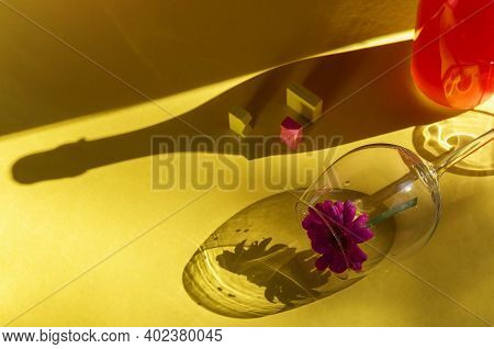 Festive Party Concept. Glass And Bottle Of Pink Champagne On A Yellow Background. Sunlight Reveals T