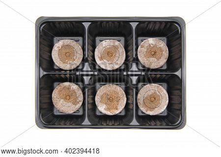 New Empty Plastic Pots In The Form Of Cells And Compressed Soil For Seedlings On A White Background.