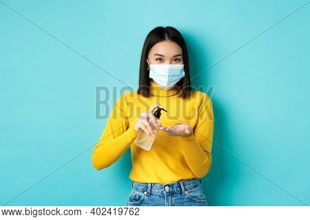 Covid-19, Social Distancing And Pandemic Concept. Smiling Asian Woman In Medical Mask Using Preventi