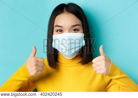 Covid-19, Social Distancing And Pandemic Concept. Close Up Of Young Asian Woman In Medical Mask Show