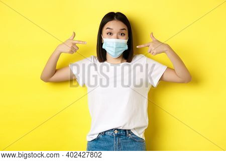Covid-19, Quarantine And Social Distancing Concept. Young Asian Woman In White T-shirt, Pointing At 