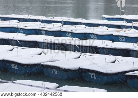 Madrid, Spain - January 08, 2021: Boats Covered With Snow And Moored In The Estanque Grande Del Reti
