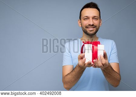 Photo Shot Of Handsome Positive Smiling Brunette Unshaven Young Man Isolated Over Blue Background Wa