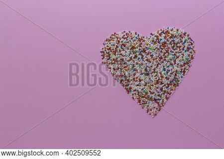 Sprinkles Arranged In A Heart Shape On A Pink Rustic Background. Valentines Day, Greeting Card. Spri