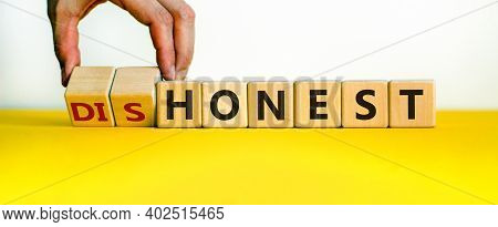 Honest Or Dishonest Symbol. Businessman Hand Turns Cubes And Changes The Word 'dishonest' To 'honest