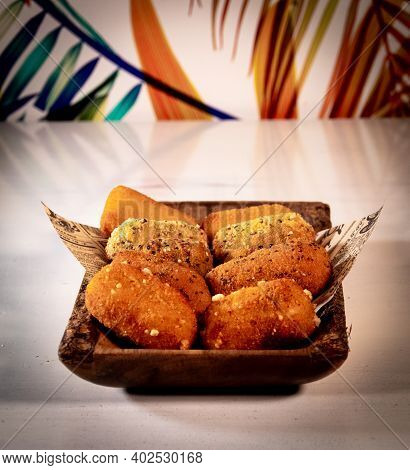 A Traditional Spanish Food Of Croquettes, Presented On A Tray With Letter Paper.the Background Is Fu