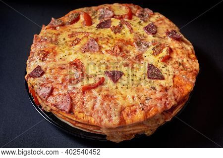 Italian Pizza Cake With Four Layers Full Of Grilled Salami, Ham And Moose Sausage. Black Background.