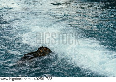Mossy Stone In Azure Water Of Mountain River Close-up. Blue Nature Background With Boulder With Moss