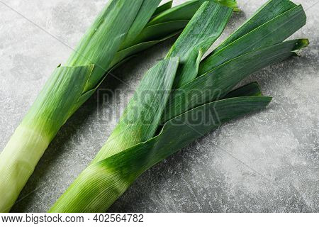 Organic Leek Onion On Grey Textured Background, Side View With Space For Text