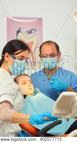 Little Girl Patient Sitting In Stomatological Chair In Dental Office, Visiting Doctor For Oral Probl