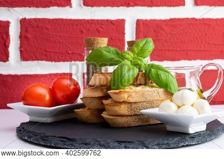 Rapeseed Oil, Basil, White Bread Croutons With Mozzarella, Spices And Tomatoes In A Cup On A Stone S