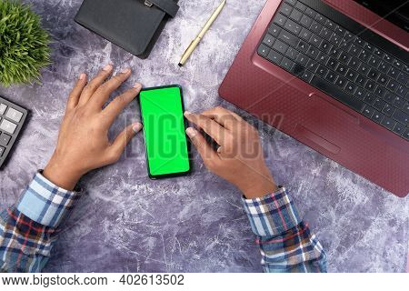 Top View Of Man Hand Using Smart Phone On Office Desk