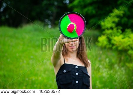 A Young Girl Plays A Tennis Ball On Velcro Outdoors. Day Off, Sunny Summer Day