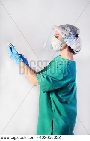 Doctor In Protective Gear Respiratory Mask And Eye Mask In Medical Latex Gloves Draws A Medicinal Fl